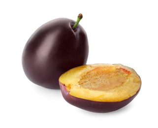 Whole and cut ripe plums on white background