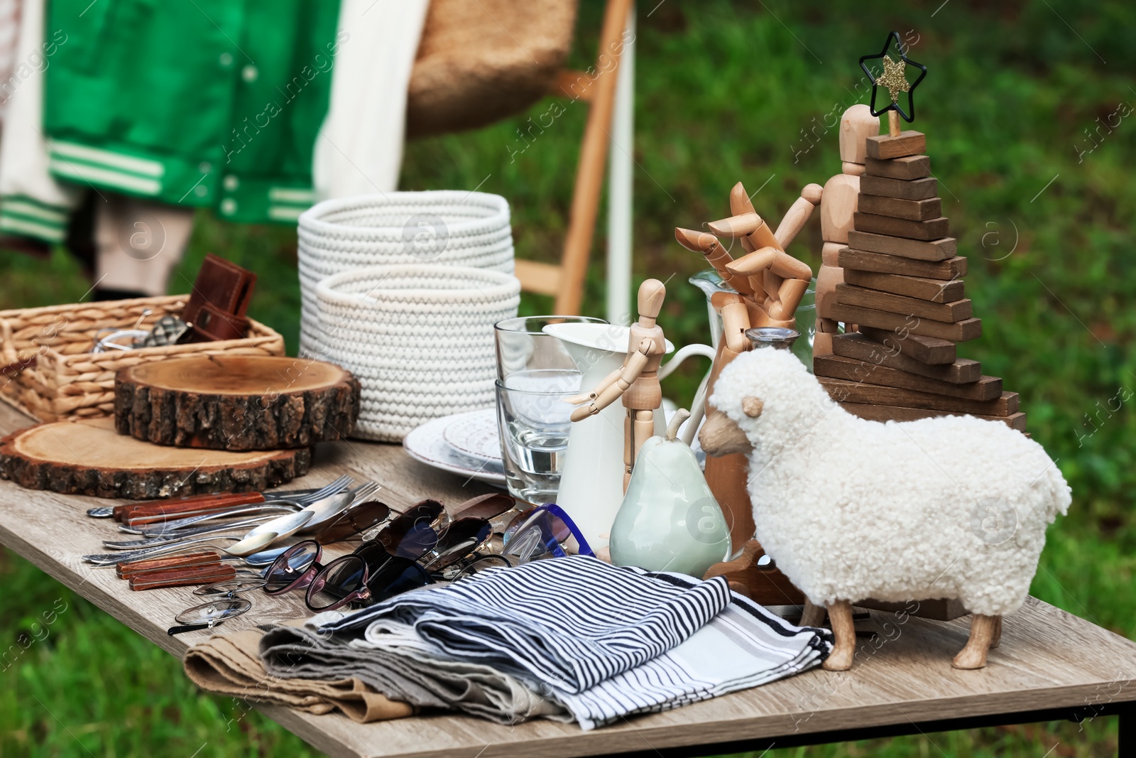 Photo of Many different decorative items on wooden table outdoors. Garage sale