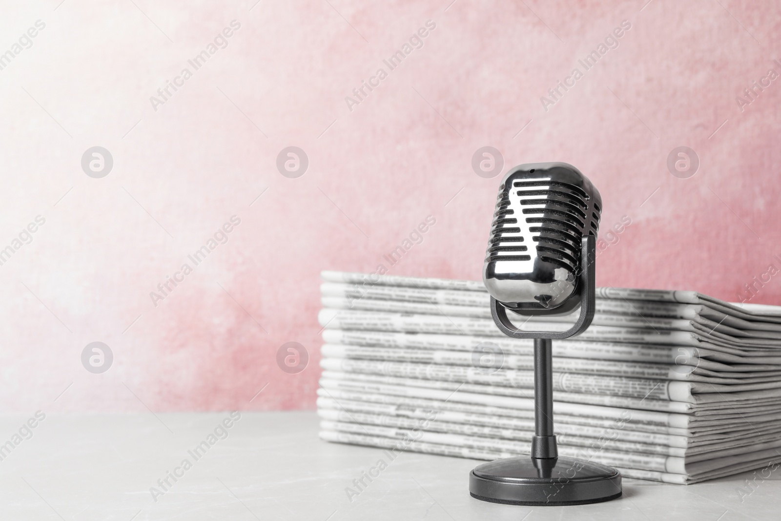 Photo of Newspapers and vintage microphone on table, space for text. Journalist's work