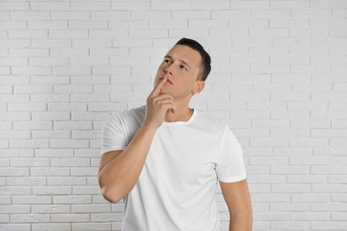 Photo of Handsome young man near white brick wall