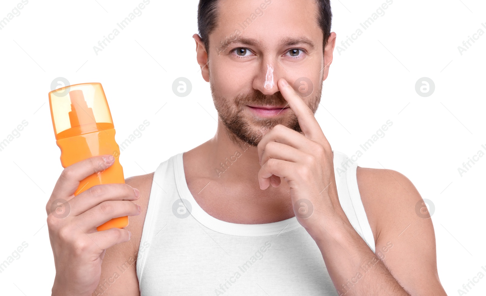 Photo of Handsome man holding bottle of sun protection cream on white background