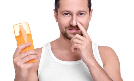 Handsome man holding bottle of sun protection cream on white background