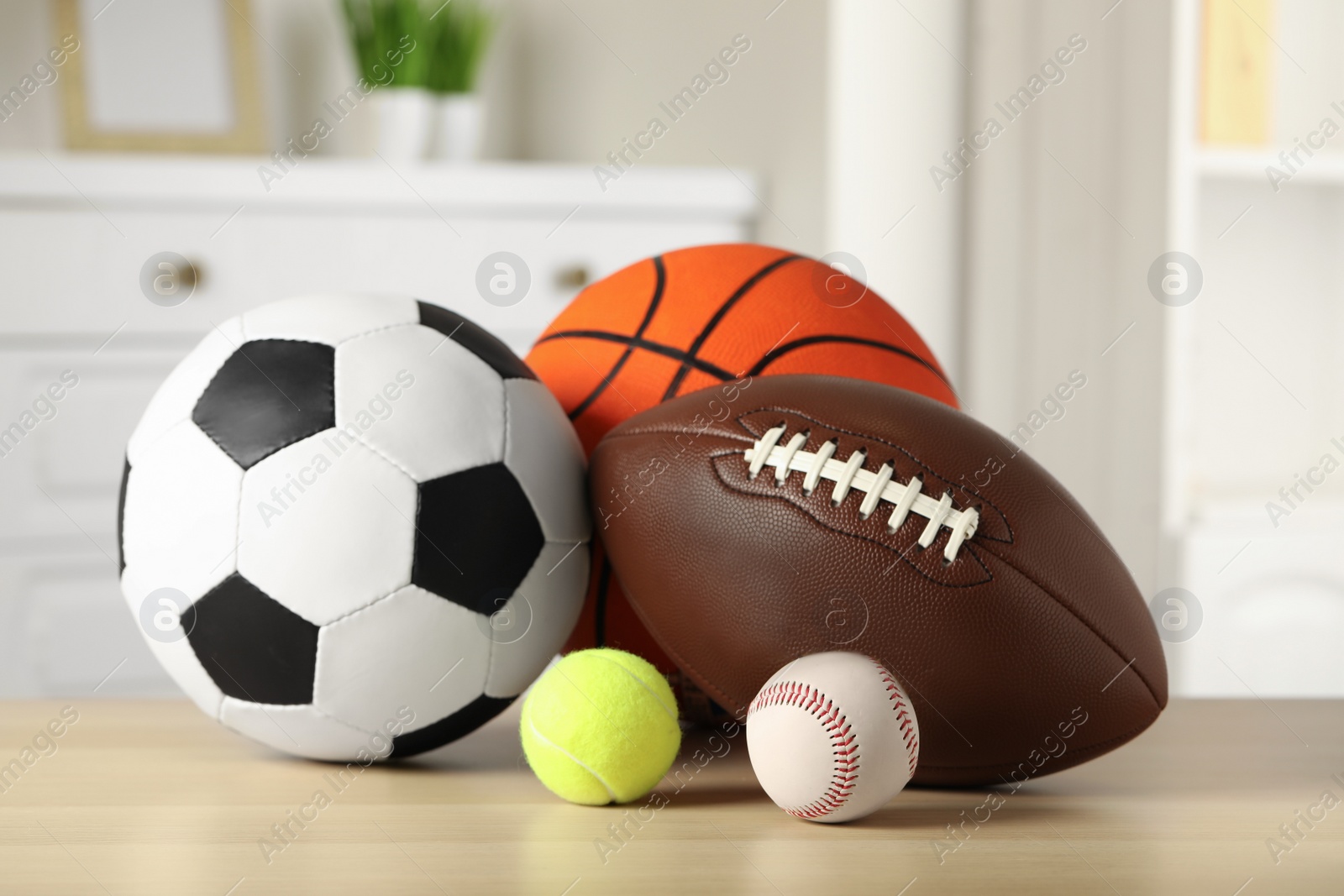 Photo of Set of different sport balls on wooden table indoors
