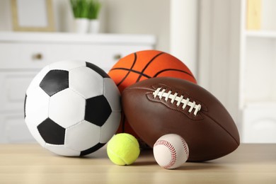 Photo of Set of different sport balls on wooden table indoors