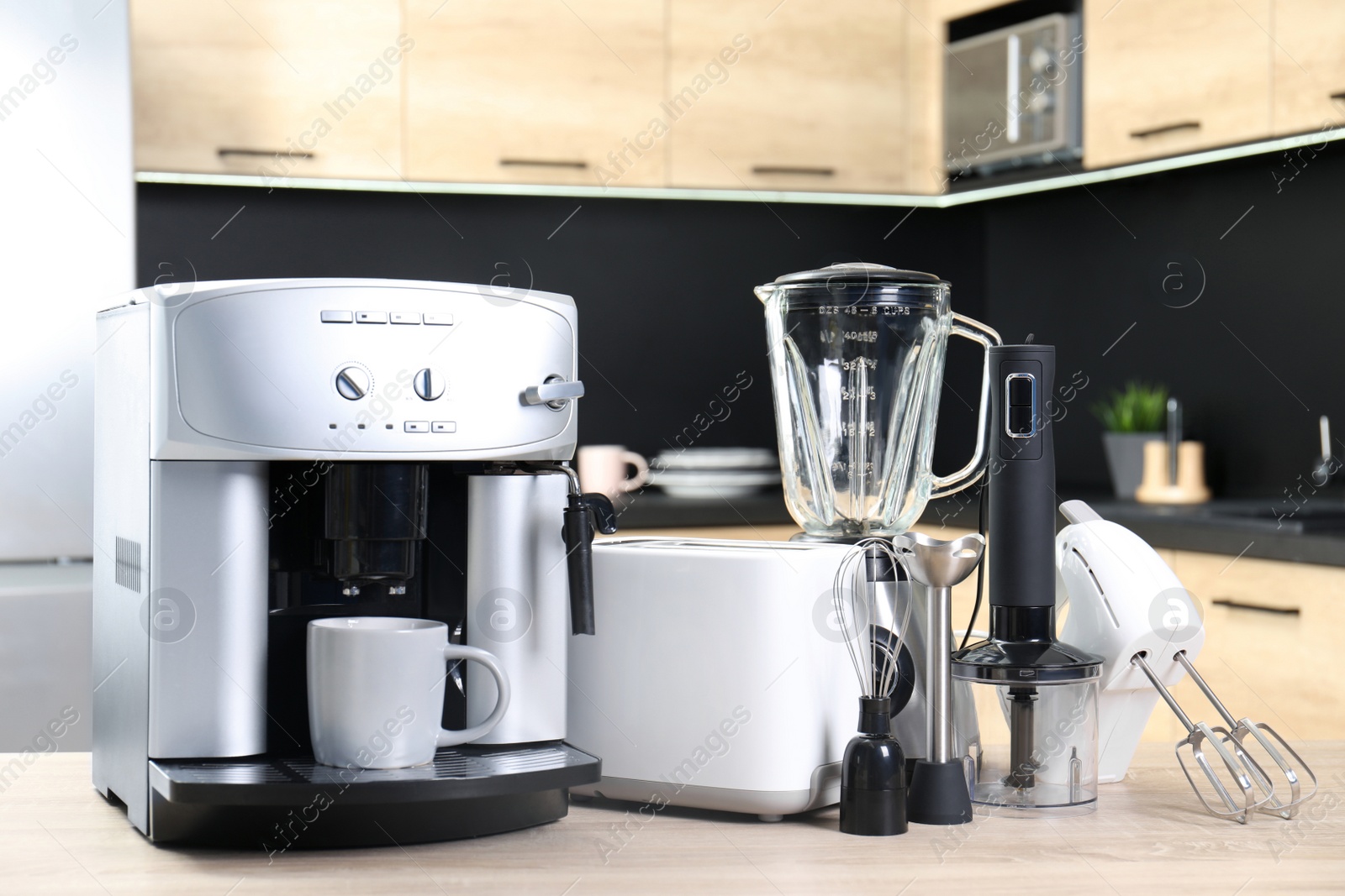 Photo of Modern domestic appliances on wooden table in kitchen