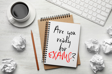 Image of Flat lay composition of notebook with phrase ARE YOU READY FOR EXAMS and on white wooden table