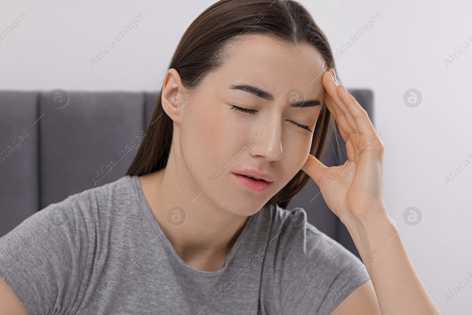 Photo of Sad woman suffering from headache at home