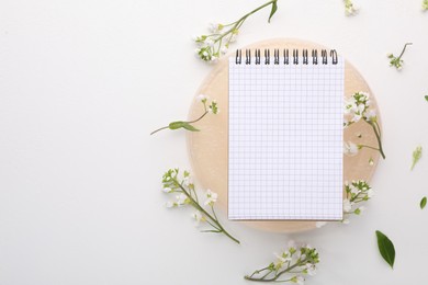 Guest list. Notebook and beautiful spring tree blossoms on white background, flat lay. Space for text