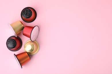 Many coffee capsules on pink background, flat lay. Space for text