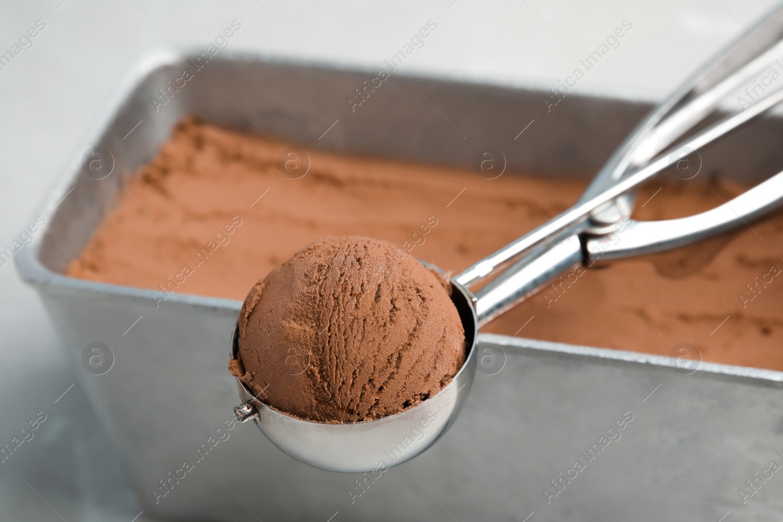 Photo of Scoop of chocolate ice cream on container, closeup