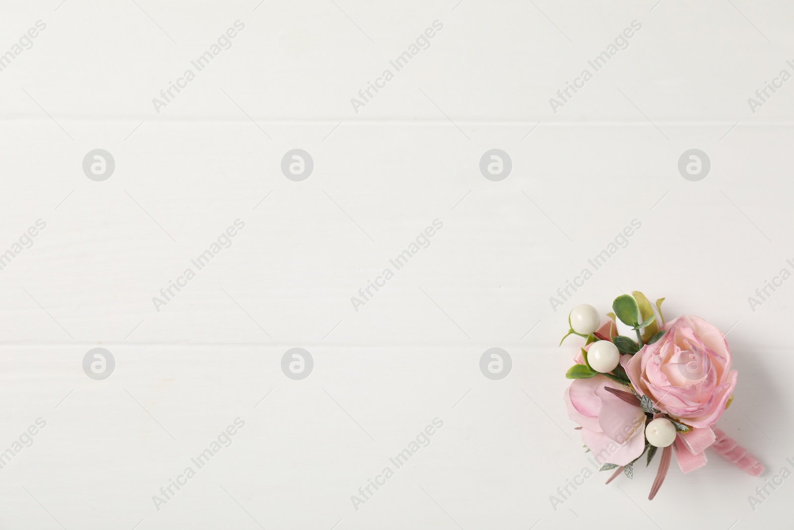 Photo of Beautiful boutonniere on white background, top view. Space for text