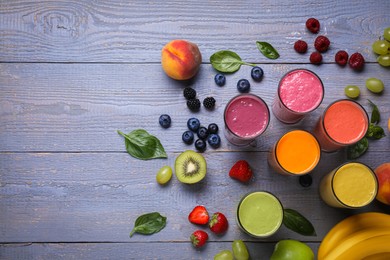Photo of Many different delicious smoothies and ingredients on grey wooden table, flat lay. Space for text