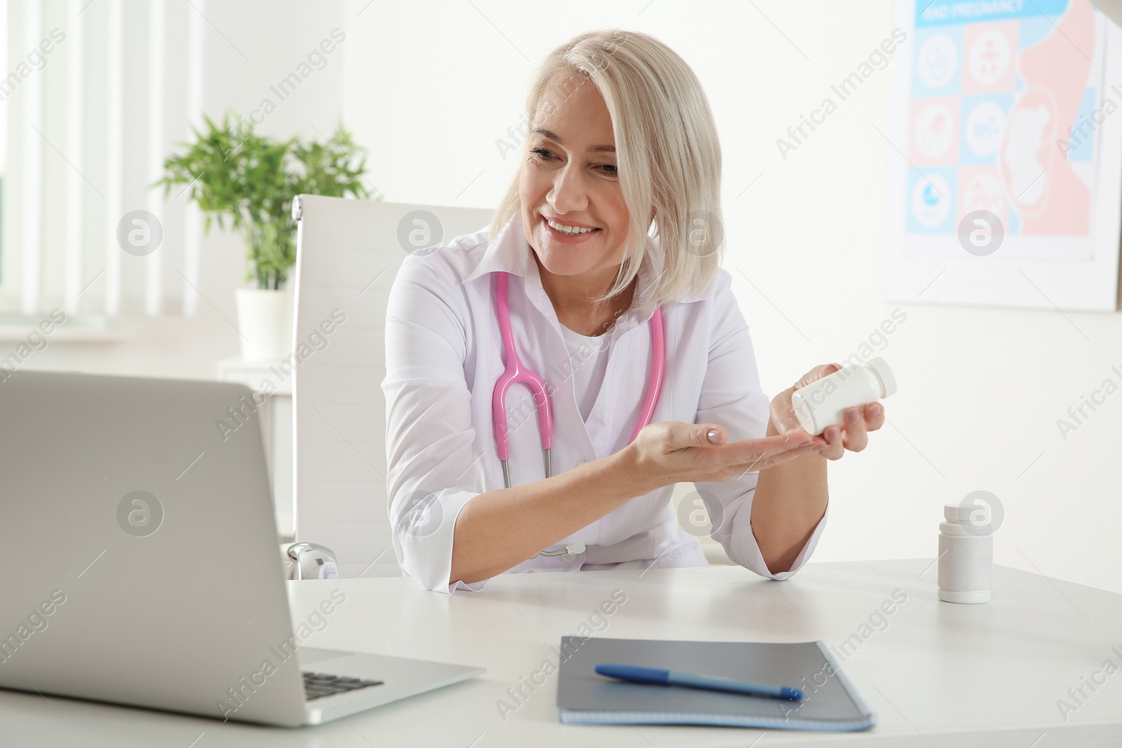 Photo of Doctor consulting patient using video chat on laptop in clinic