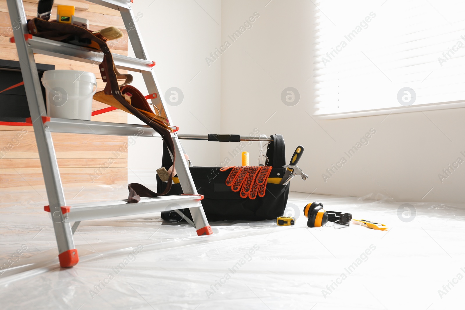 Photo of Stepladder and different tools in room. Interior renovation