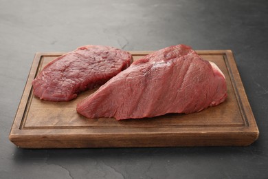 Pieces of raw beef meat on black table