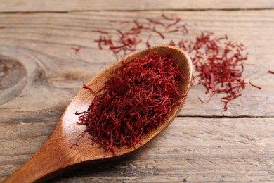 Photo of Aromatic saffron and spoon on wooden table, top view