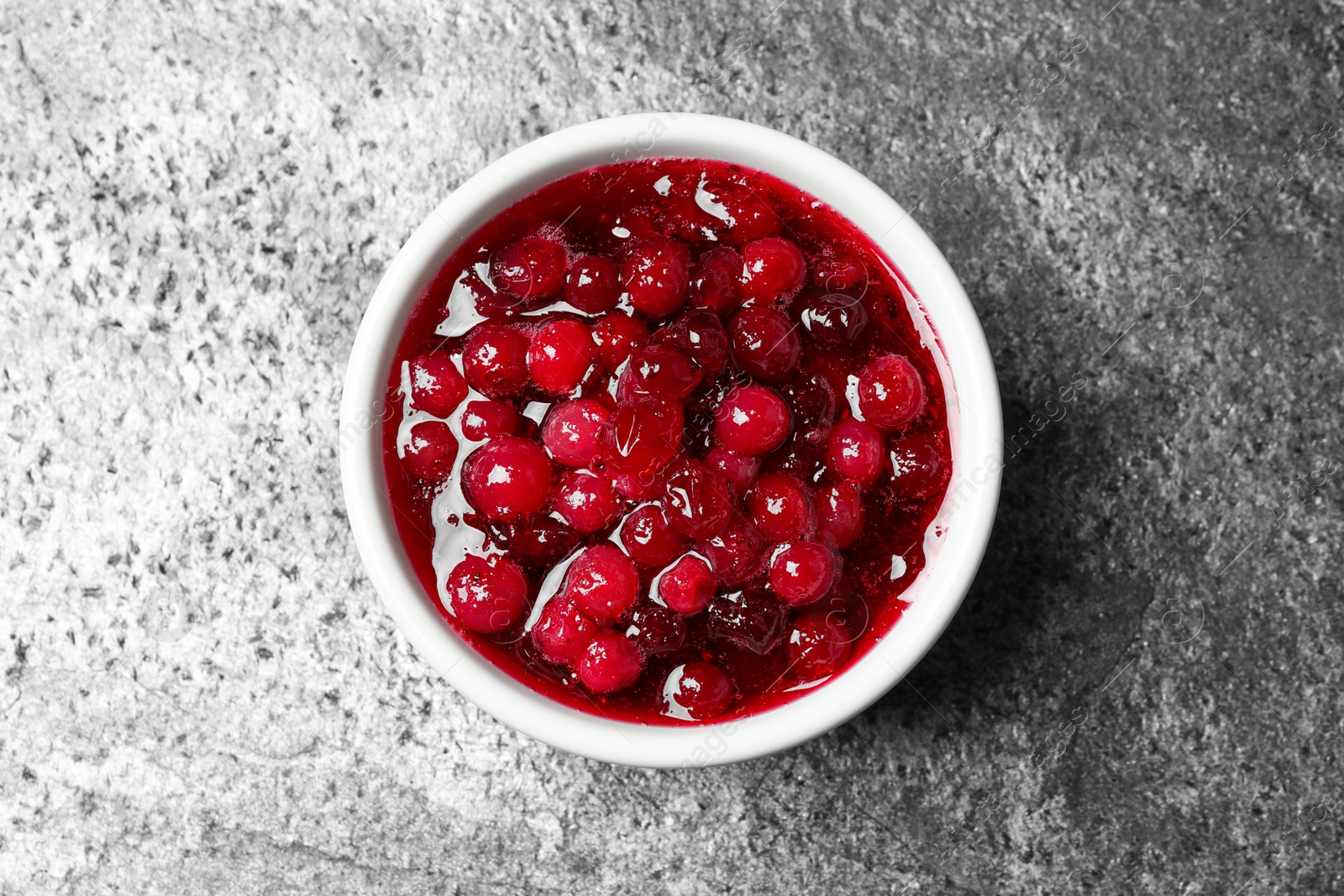 Photo of Fresh cranberry sauce on grey table, top view