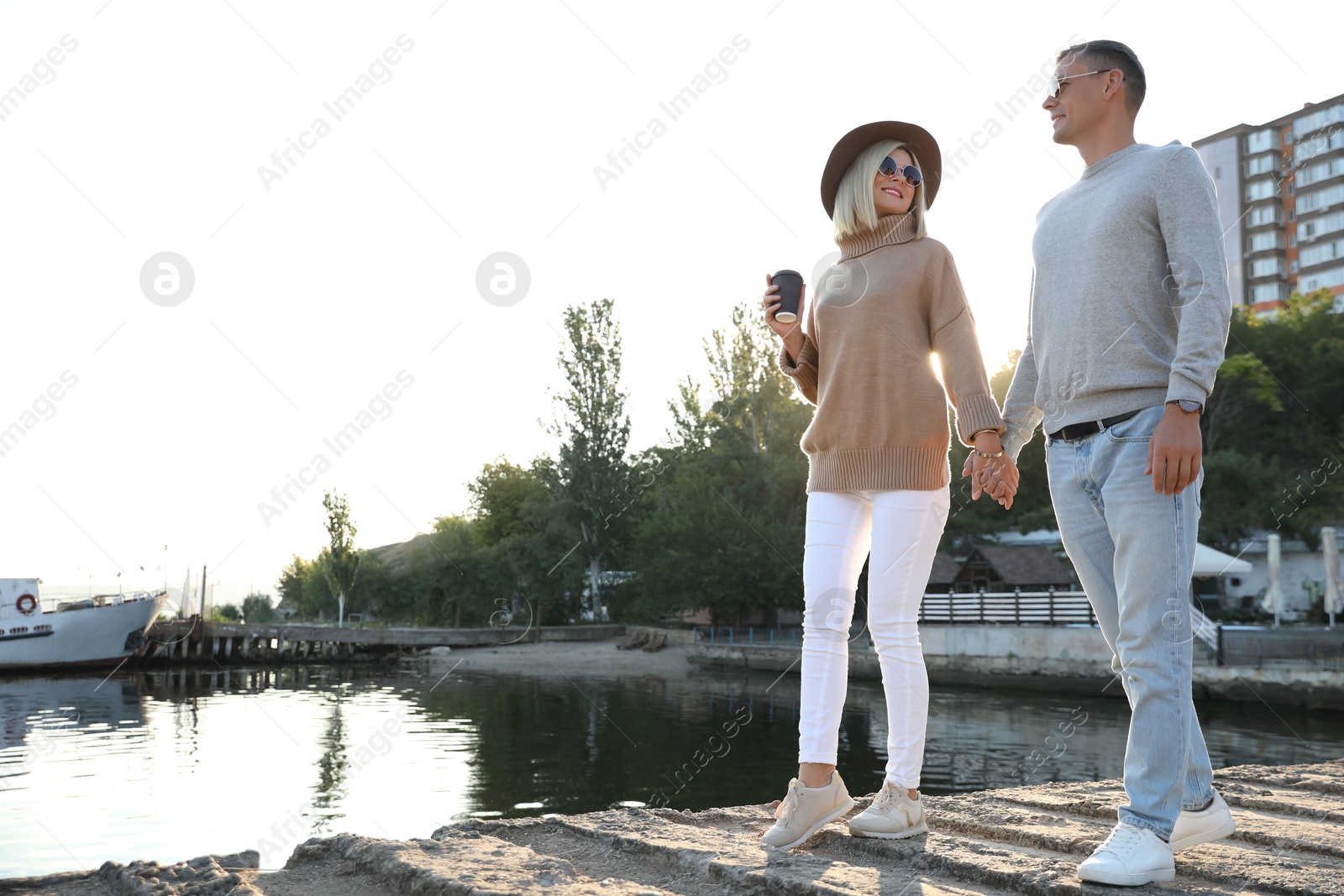 Photo of Couple in stylish sweaters on city pier