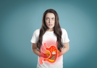 Image of Woman suffering from heartburn on turquoise background. Stomach with erupting volcano symbolizing acid indigestion, illustration