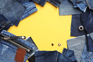 Photo of Frame made of cut jeans on yellow background. Space for text