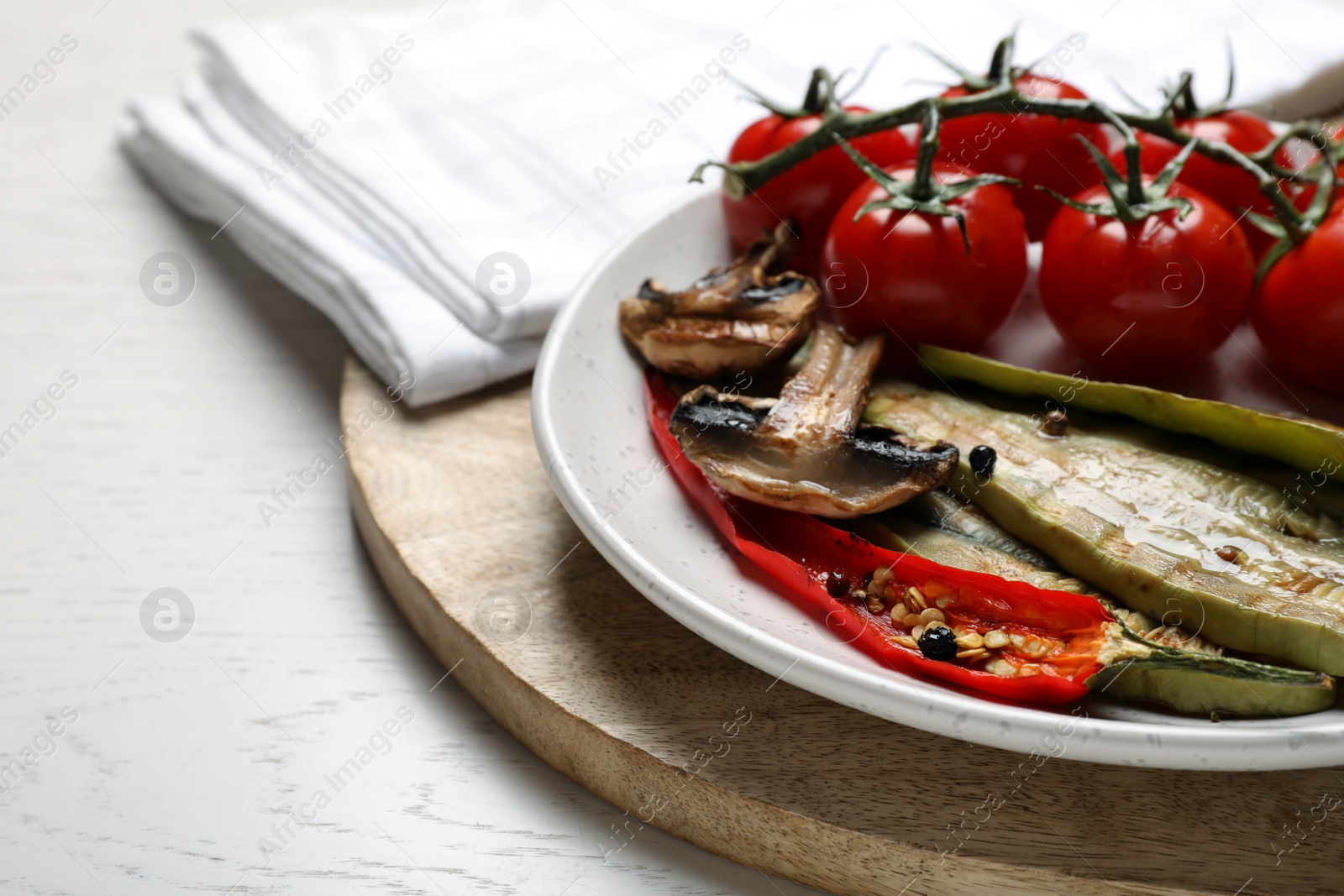 Photo of Delicious grilled vegetables served on white wooden table, closeup. Space for text
