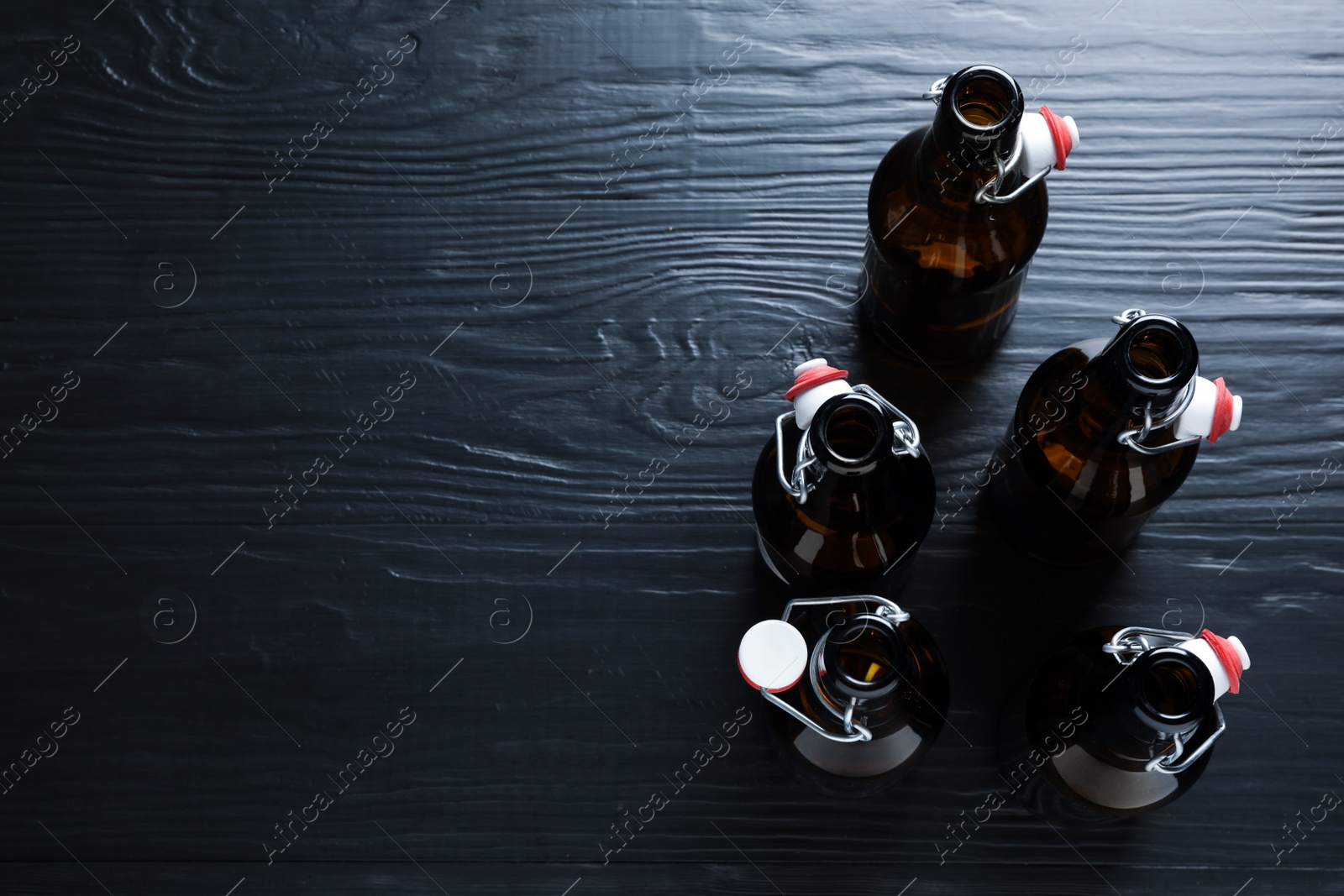 Photo of Many bottles of beer on wooden background, view from above