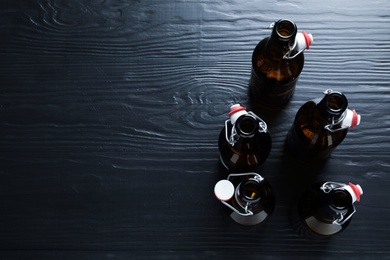 Photo of Many bottles of beer on wooden background, view from above