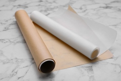 Photo of Rolls of baking paper on white marble table