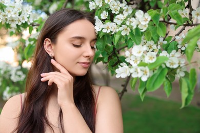 Beautiful woman near blossoming tree on spring day