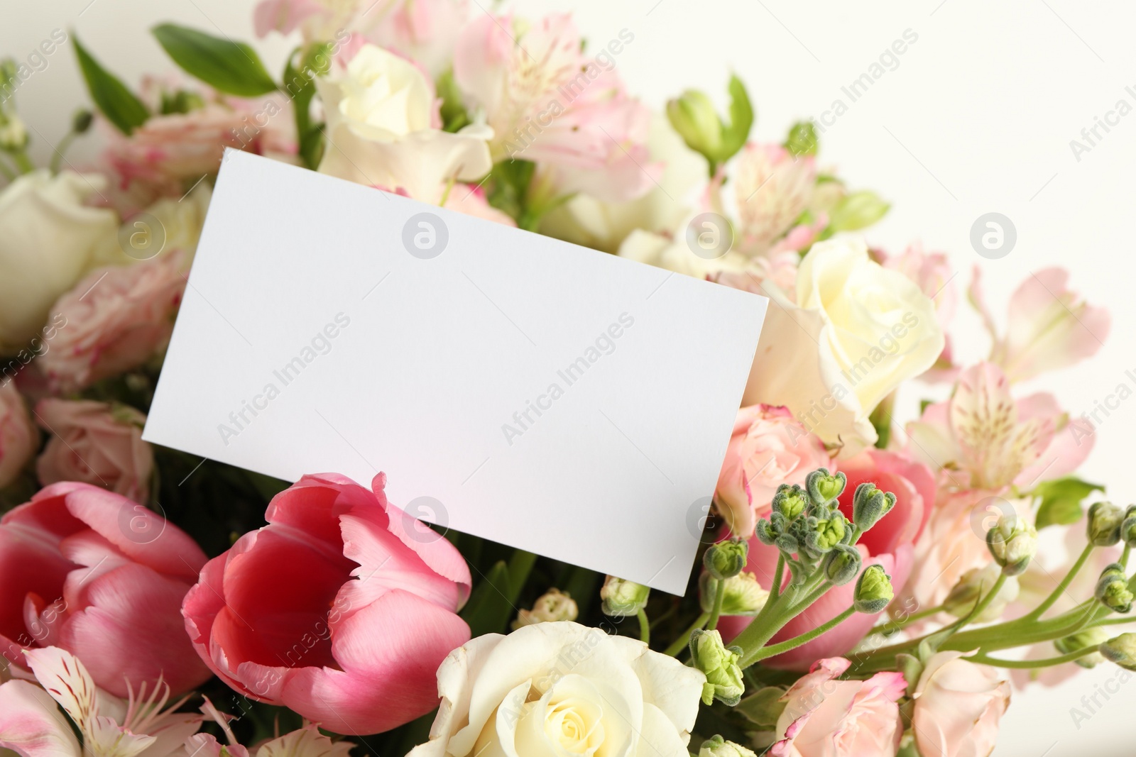 Photo of Happy Mother's Day. Beautiful flowers with blank card on light background, closeup