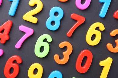 Photo of Colorful numbers on dark gray background, flat lay