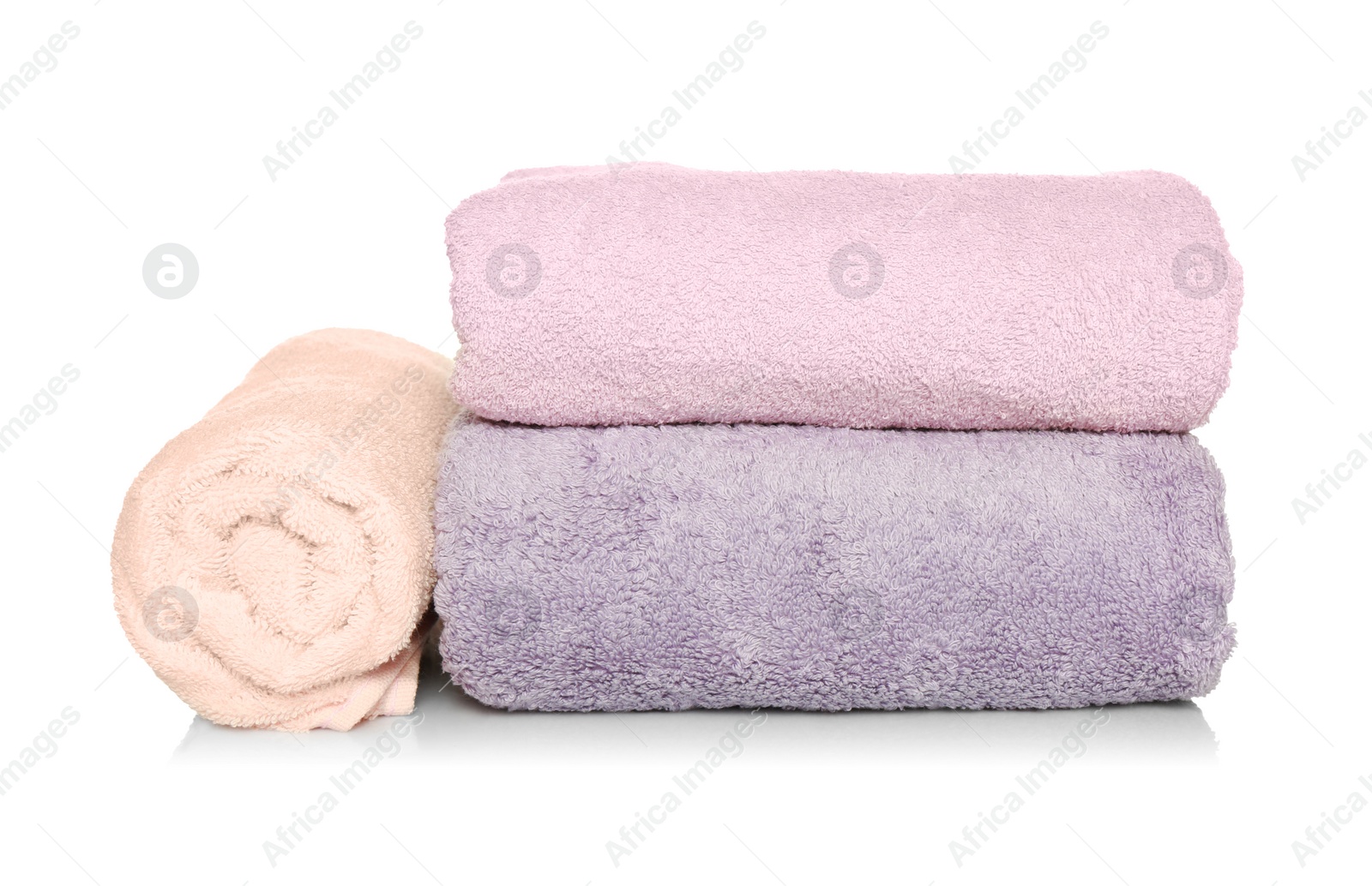 Photo of Folded and rolled soft terry towels on white background