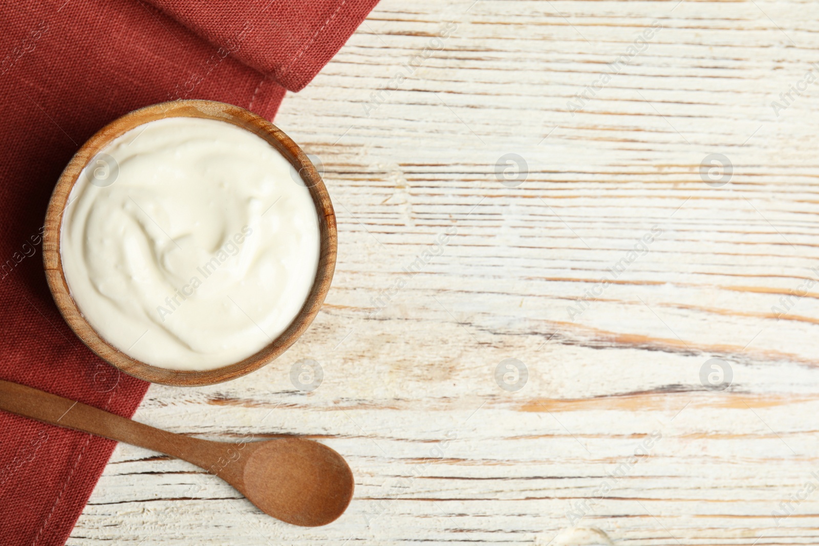 Photo of Tasty organic yogurt on white wooden table, flat lay. Space for text