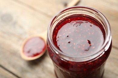 Photo of Homemade delicious raspberry jam on table, closeup