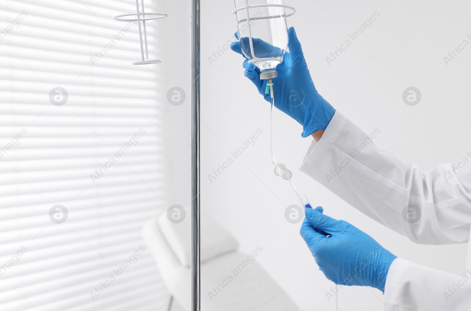 Photo of Nurse setting up IV drip in hospital, closeup