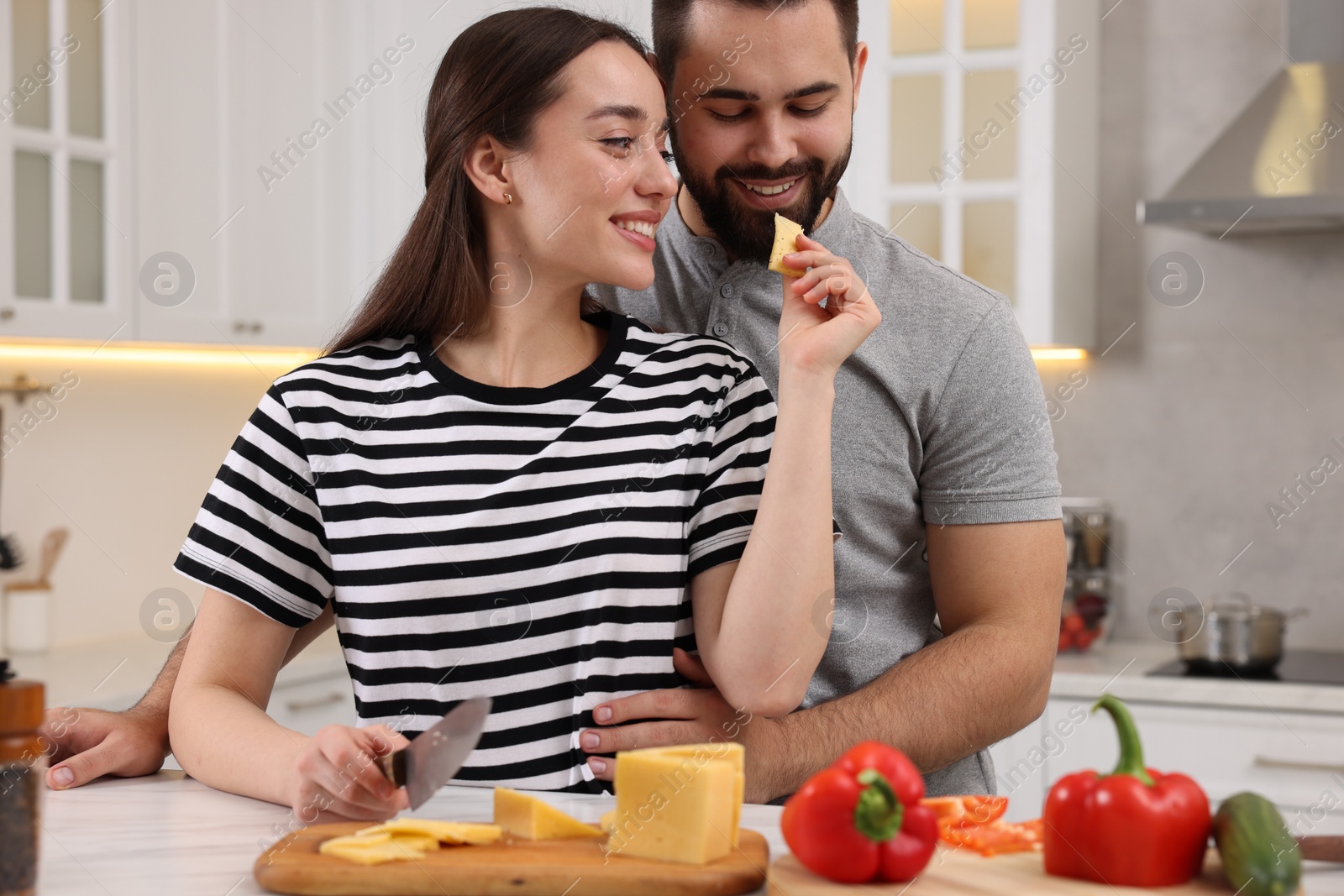 Photo of Lovely young couple cooking together in kitchen