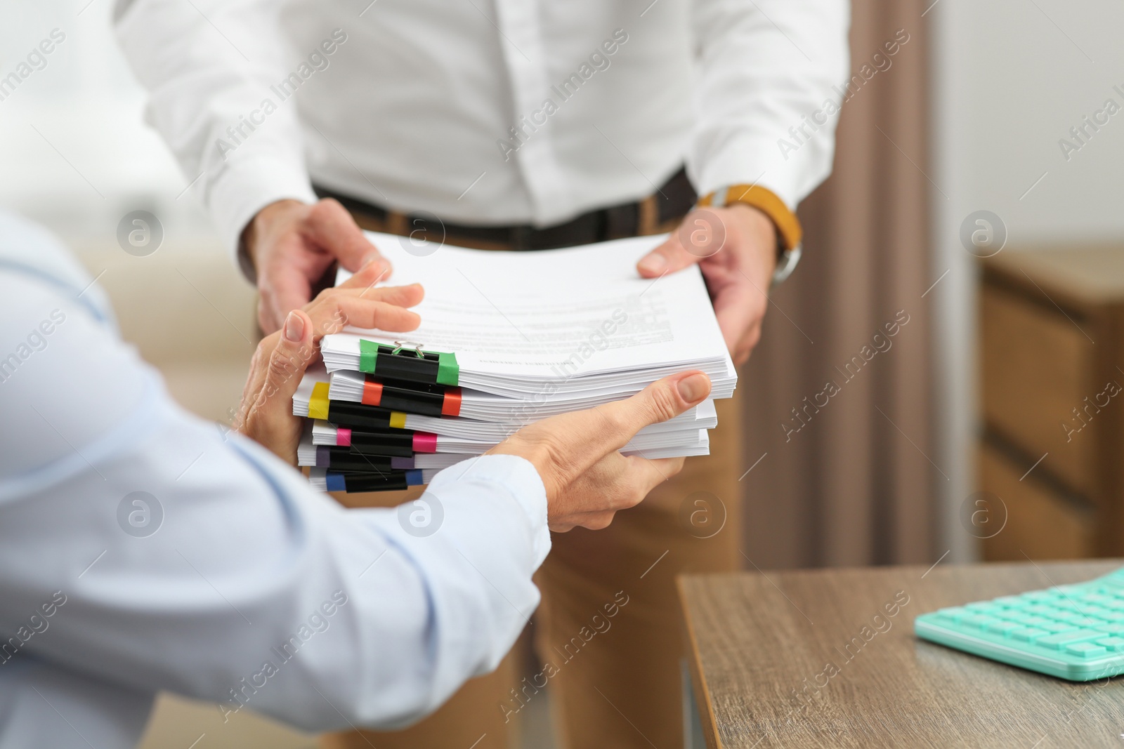 Photo of Woman giving documents to colleague in office, closeup