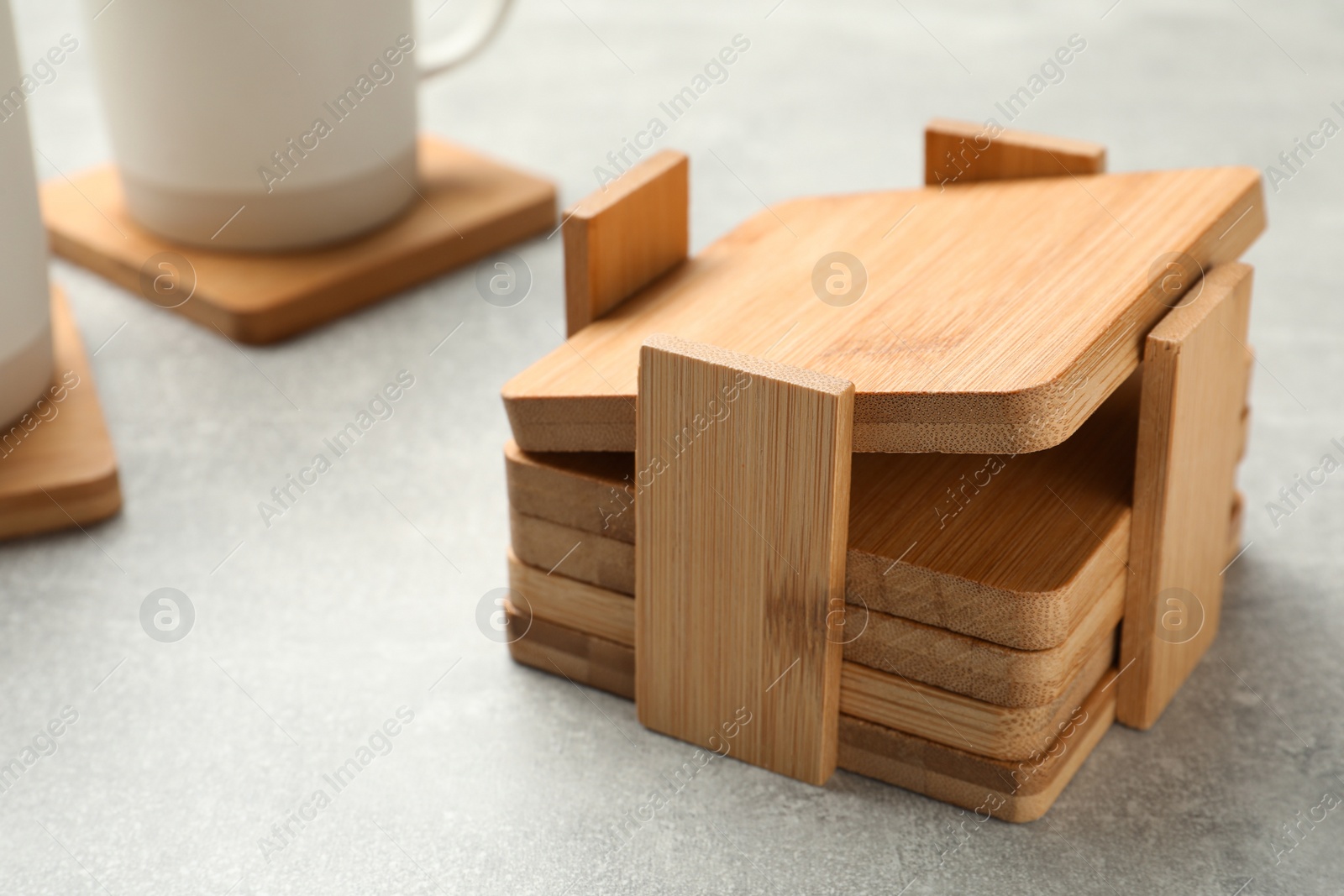 Photo of Stylish wooden cup coasters on light grey table