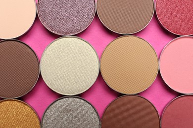 Photo of Beautiful eye shadow refill pans on pink background, flat lay