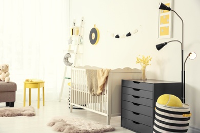 Photo of Stylish baby room interior with crib