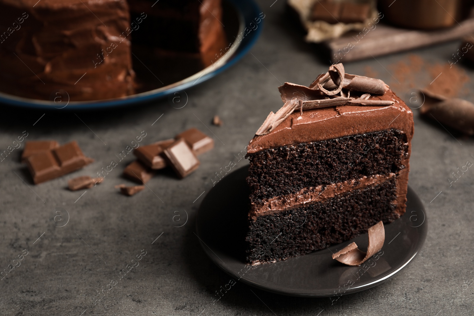 Photo of Plate with slice of tasty homemade chocolate cake on grey table. Space for text