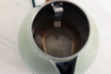 Photo of Electric kettle with limescale on table, above view