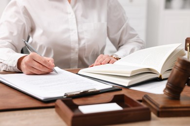 Lawyer working with documents at wooden table in office, closeup