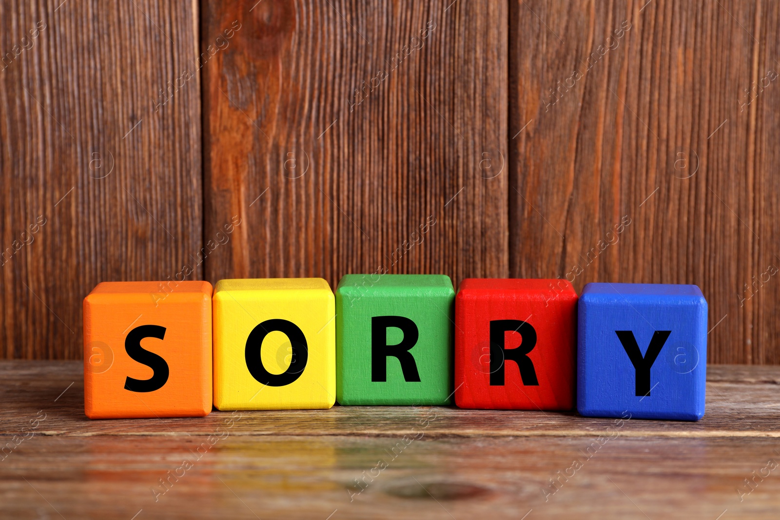 Image of Apology. Word Sorry made of colorful cubes on wooden table