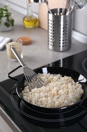 Cooking tasty rice on induction stove in kitchen