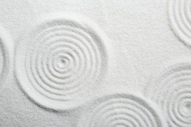Photo of Zen rock garden. Circle patterns on white sand, top view
