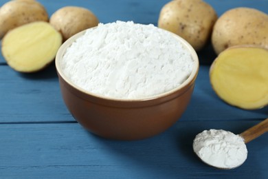 Starch and fresh potatoes on blue wooden table, closeup