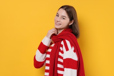 Photo of Beautiful woman in warm scarf on yellow background