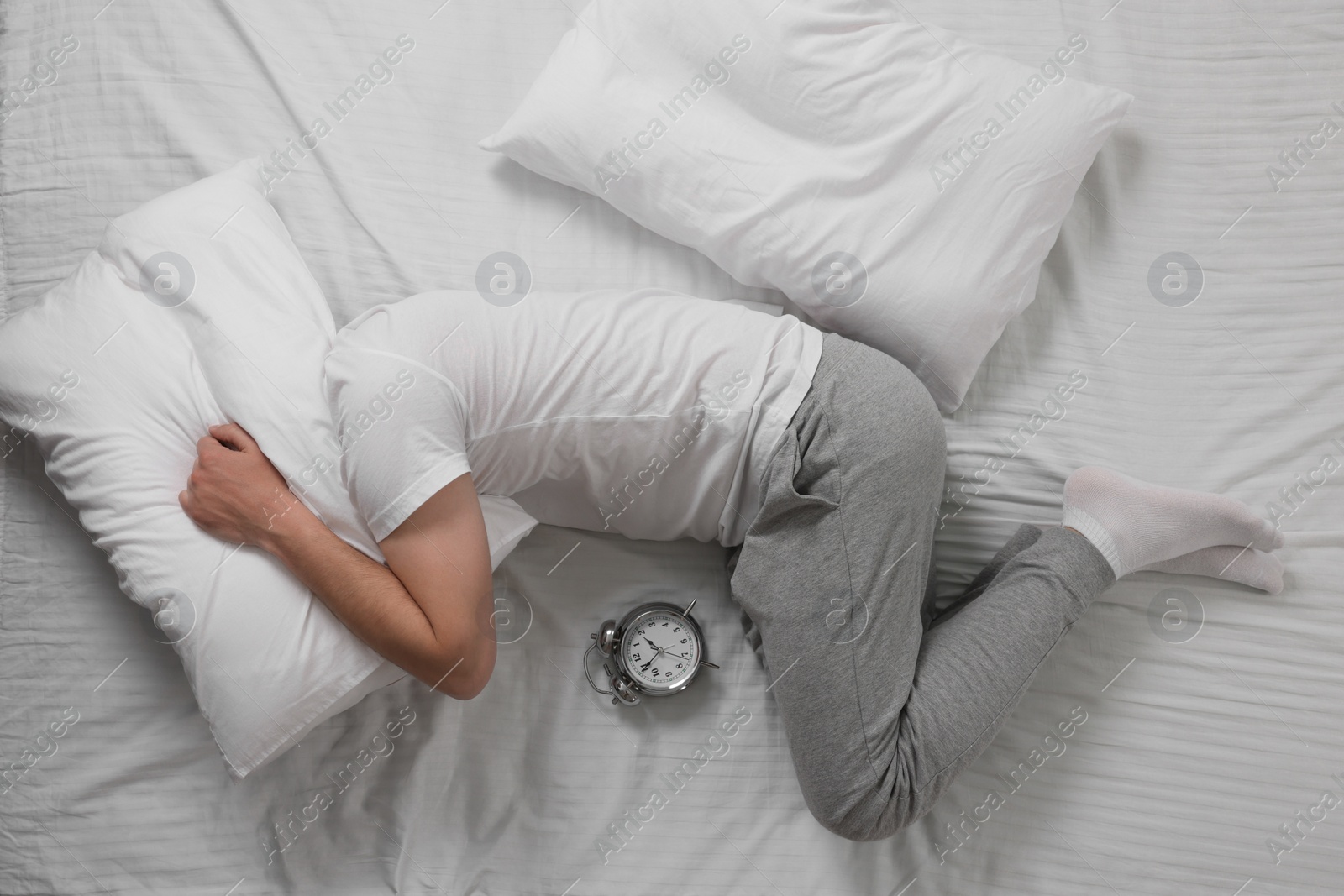 Photo of Man suffering from insomnia in bed, top view