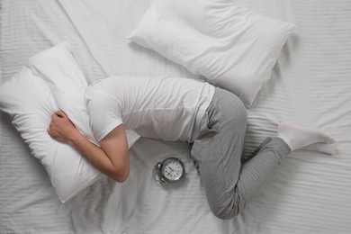 Man suffering from insomnia in bed, top view